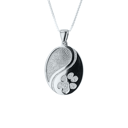 GIF of silver pendant with two engraved designs. 