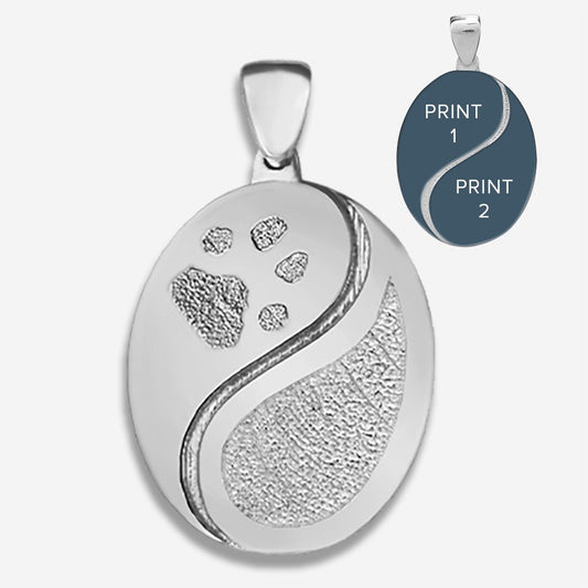 Silver pendant with engraved designs on a white background